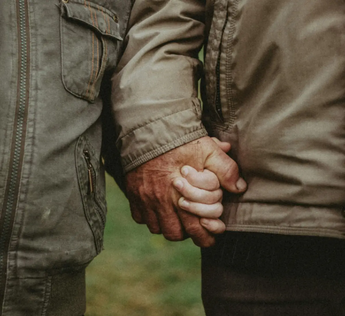 An older person holds hands with a child